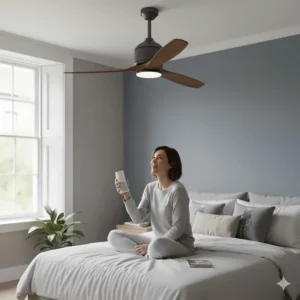 A person using an Echo Dot to give voice commands to a smart ceiling fan in a modern UK bedroom.