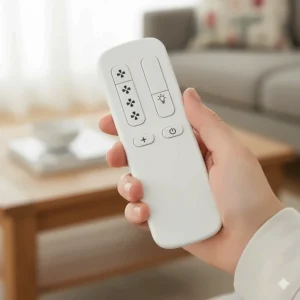 Close-up of a handheld white remote control for a ceiling fan clearly showing buttons for fan speed and light dimming functions.