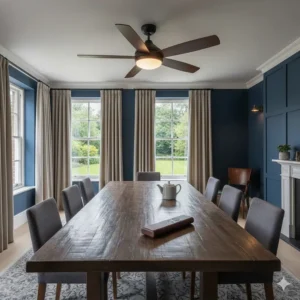 An elegant dark wood ceiling fan with remote control in a classic UK dining room with navy blue walls and a large timber table.