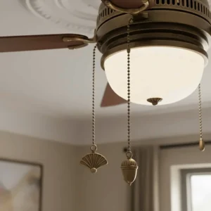 Close-up of twin decorative pull cords on a classic ceiling fan, typical of traditional UK home styling.