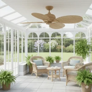 A sustainable rattan ceiling fan installed in a light-filled UK conservatory with wicker furniture.