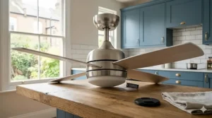 A brushed steel ceiling fan fitting adding a contemporary aesthetic to a compact kitchen design.