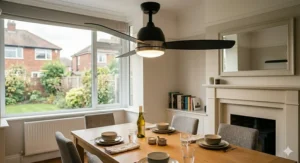 A high-resolution, photorealistic 4K close-up detail shot focusing specifically on a contemporary ceiling fan with an integrated, dimmable frosted glass dome light fixture. It is centred over a light oak dining table set for dinner with the minimalist ceramic bowls, plates, and wine bottle consistent with previous images. The turning fan blades showcase the dual functionality.