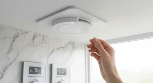 Close-up of a modern bathroom ceiling extractor fan with clear acrylic detailing showing touch control panels for relative humidity percentage and an over-run timer.