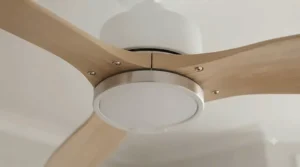 A professional installer mounting a flush-fit ceiling fan to a standard ceiling bracket.