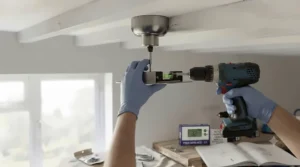 Close-up of a secure mounting bracket being fitted to a ceiling joist during a garage fan installation.