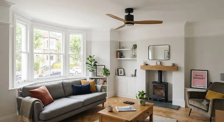 A modern low-profile hugger ceiling fan installed in a stylish UK living room with a wood-burning stove and sash bay window. short drop ceiling fans