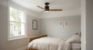 Close-up low-angle view of an oak-bladed hugger ceiling fan with integrated light mounted to a plaster ceiling.