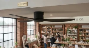Commercial ceiling fan with an extended drop rod fitting securely into a high timber-beamed retail ceiling.