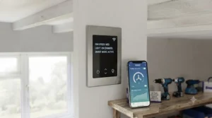 Close-up of a wall-mounted remote control and smart app interface for adjusting garage ceiling fan speeds.