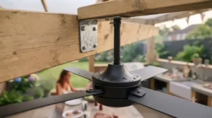 Industrial-style outdoor ceiling fan securely mounted to the wooden crossbeams of a modern garden pergola over a brick-built barbecue.