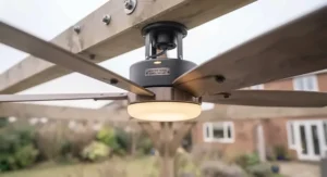 Low-profile flush mount ceiling fan securely fitted to a wooden pergola ceiling with limited clearance.