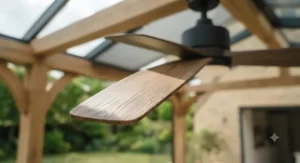 Traditional oak-effect ceiling fan blades complementing the rustic wooden décor of a glazed garden room.