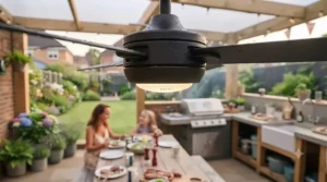 Low-profile outdoor ceiling fan featuring a warm white LED light fixture illuminating an outdoor kitchen and barbecue preparation space.
