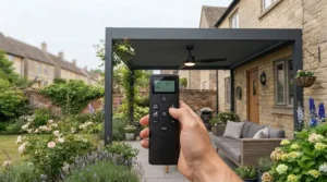 Hand holding a remote control adjusting the speed and LED light of a pergola ceiling fan