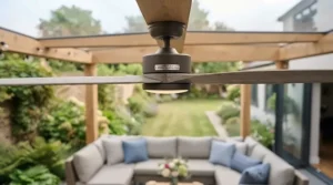 Hand holding a smart remote control adjusting the speed of an outdoor patio ceiling fan.