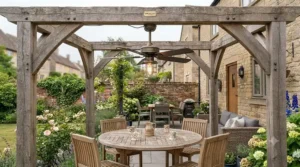 Traditional oak timber pergola featuring a rustic outdoor ceiling fan over a patio dining table