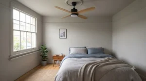 Diagram illustrating a reversible ceiling fan spinning anti-clockwise in summer mode for a cooling breeze.