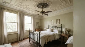 A decorative antique brass ceiling fan for period property complementing dark wood furniture in an Edwardian master bedroom.